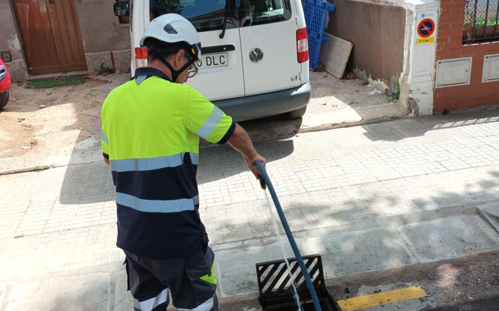 Un operari fent la neteja d'un embornal