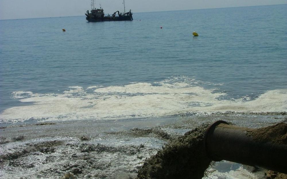 Draga fent l'abocament de sorra a la platja