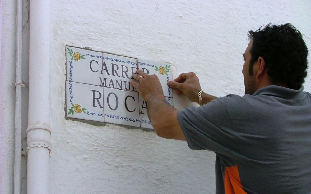 Un operari de la brigada municipal realitzant el canvi a una de les plaques del carrer Manuel Roca