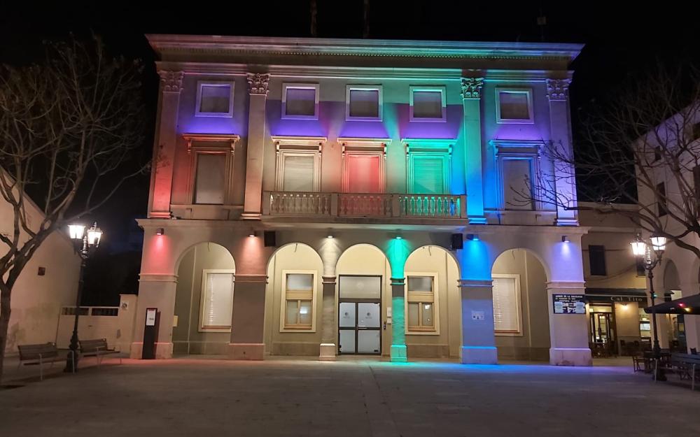 Façana de l'Ajuntament il·luminada amb els colors de l'arc de Sant Martí