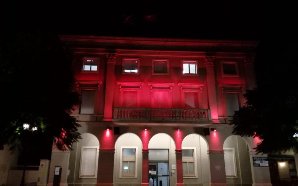 Façana de l'Ajuntament il·luminada de color vermell