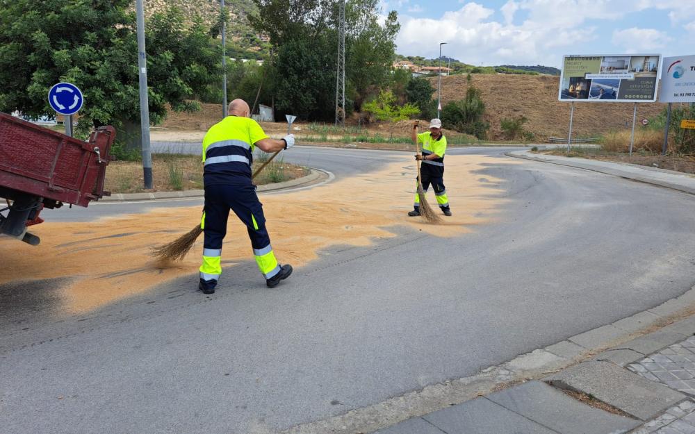 Operaris netejant l'oli que s'ha vessat a l'avinguda del Progrés